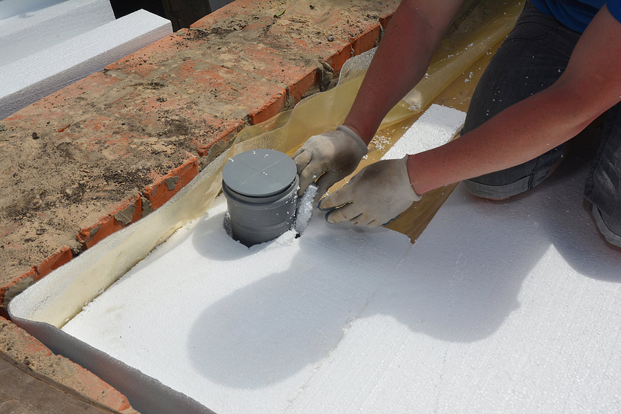 A building contractor is installing rigid foam board insulation - Wilton Insulation