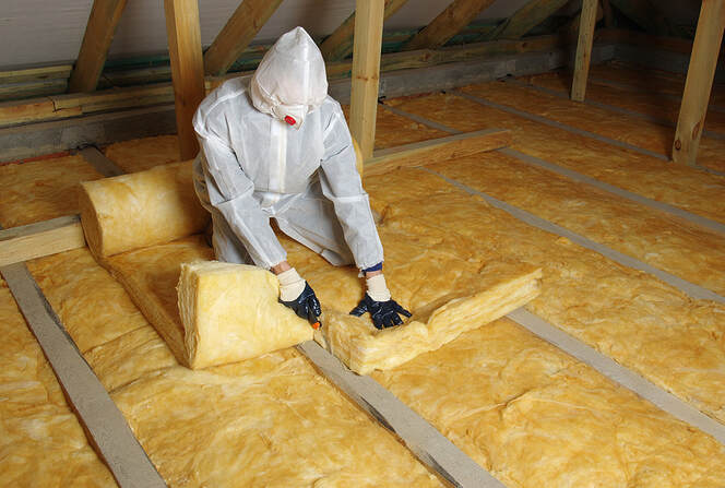 Person rolling out insulation to install it in Wilton, CT.
